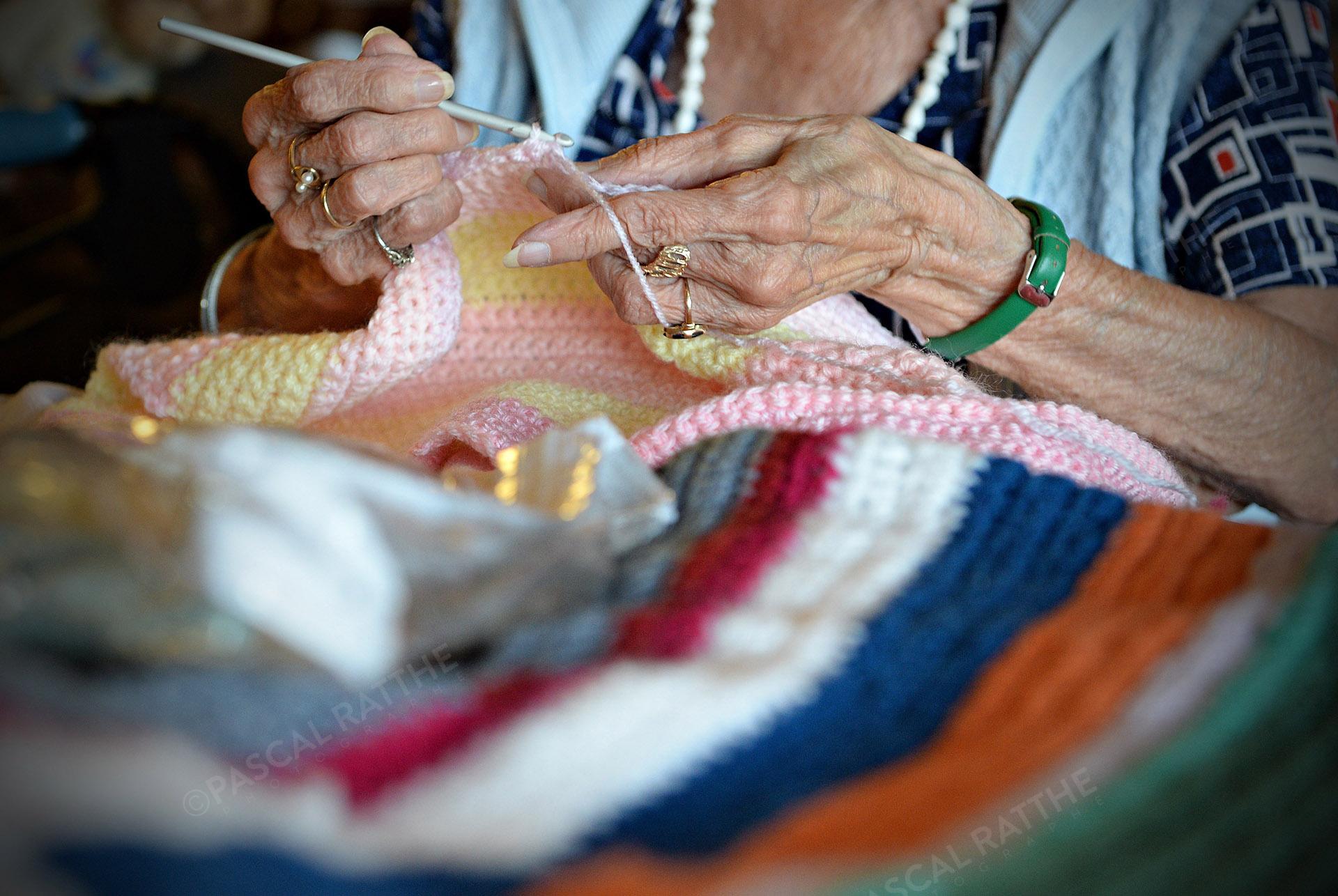 les mains d'une personne âgé faisant du tricot